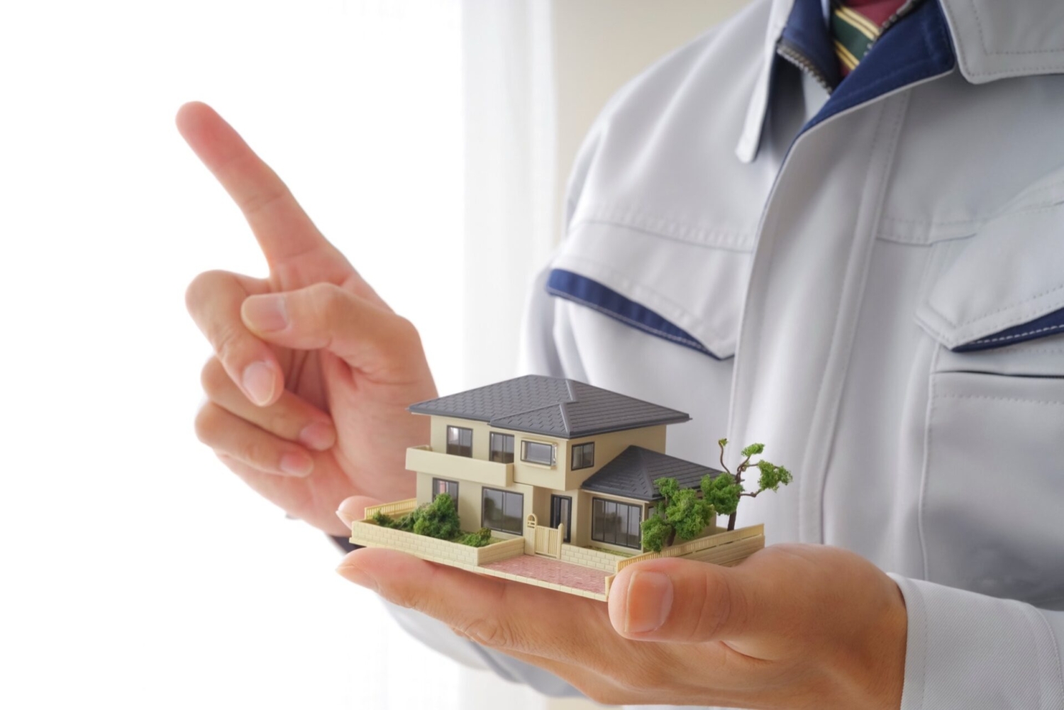 重要なポイントについて、家の模型を持ちながら解説するリフォームスタッフ