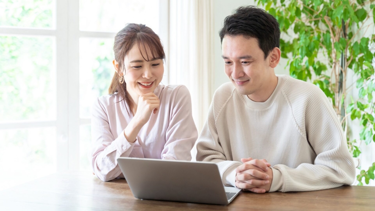 パソコンで住宅に関する情報収集をする夫婦